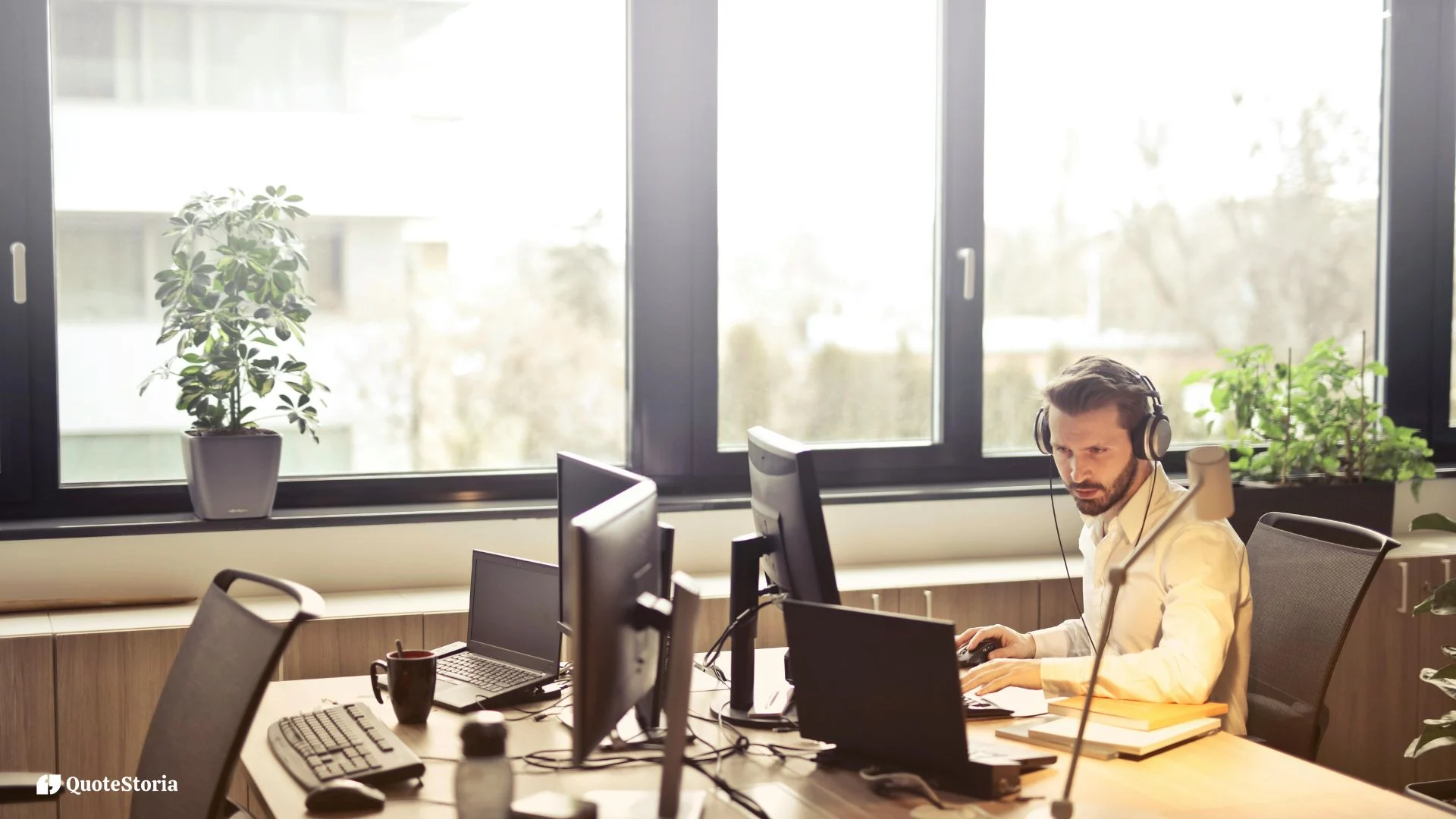 Office worker sitting at a desk and looking at a computer monitor in a modern workplace.