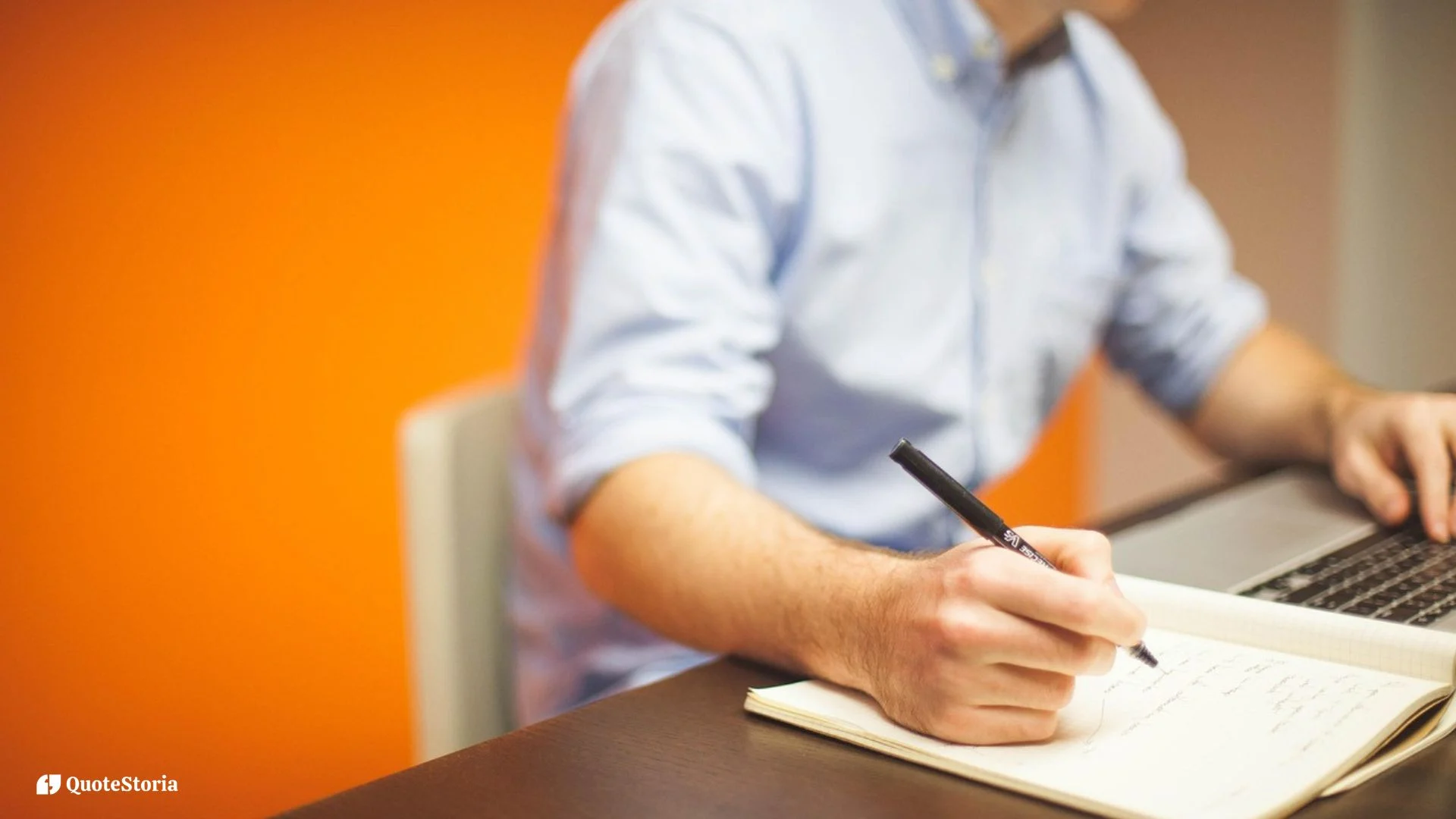 Image of a hand pausing to reflect before writing in a journal.