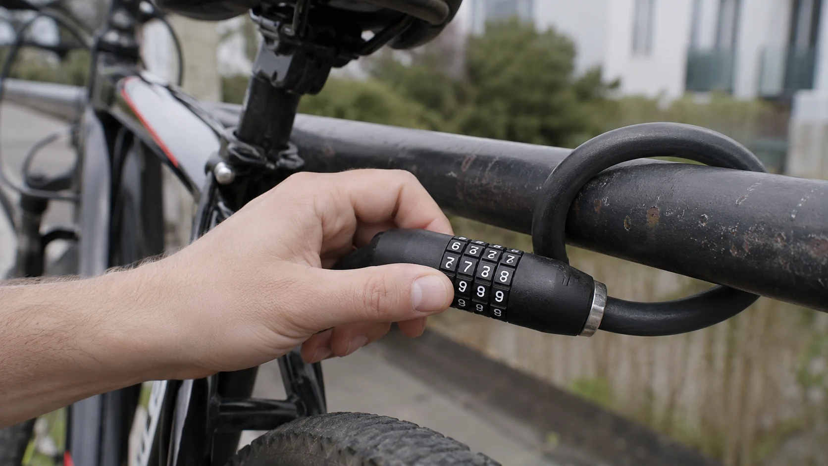 hand turning a bike combination lock dial outdoors