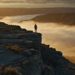 Featured image for quotes on courage and virtue showing a person standing at a cliff edge at sunrise, symbolizing moral courage and freedom.